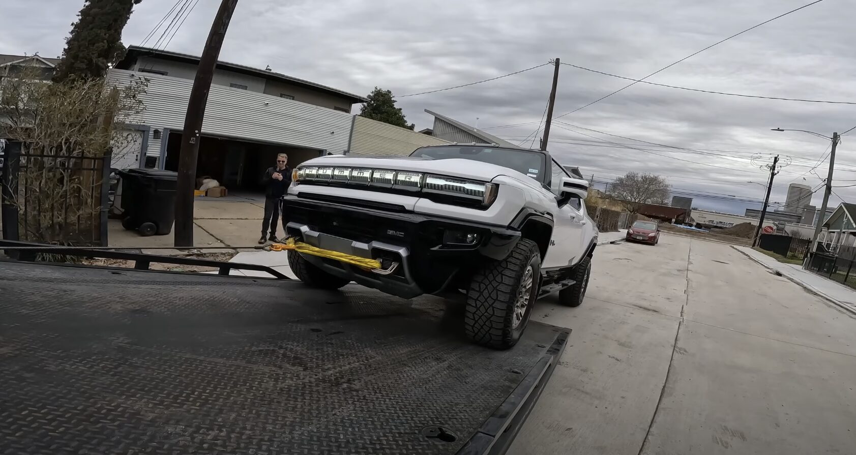 Professional car towing service showing a white truck being loaded onto a flatbed tow truck