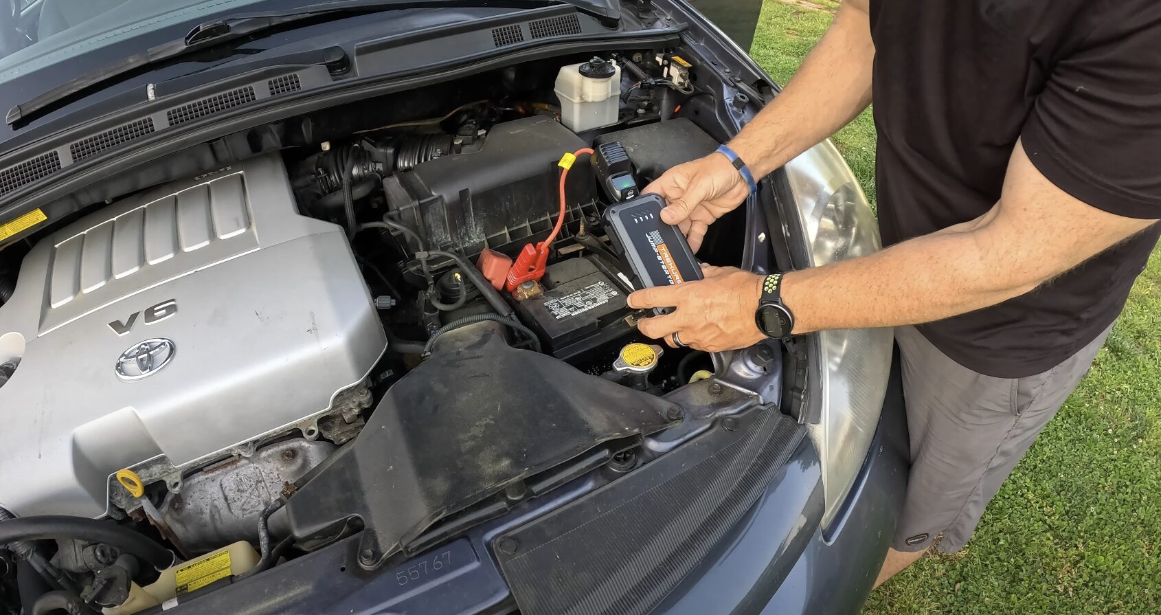Expert roadside assistance and battery jump-start service Professional towing service technician jump-starting a car battery in Bowie, MD